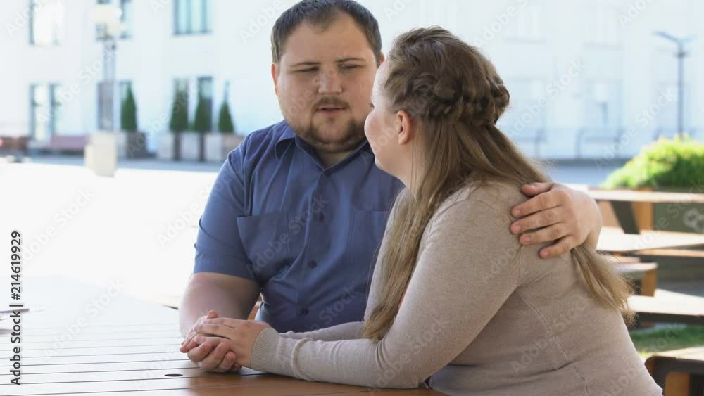 Obese young couple talking holding hands spending time together, family planning Obese young couple talking holding hands spending time together, family planning