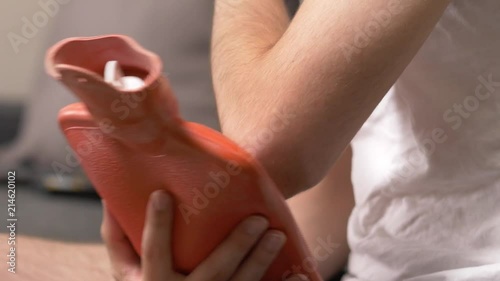 Wallpaper Mural Feeling pain in the elbow area and holding a hot water bag on it to relief the pain from the injury Torontodigital.ca