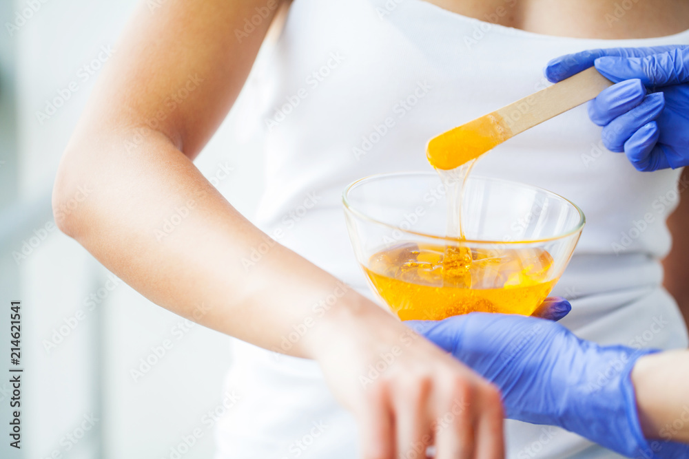 Master does epilation of hands with help of sugar paste hot wax in salon beauty Master does epilation of hands with help of sugar paste hot wax in salon beauty