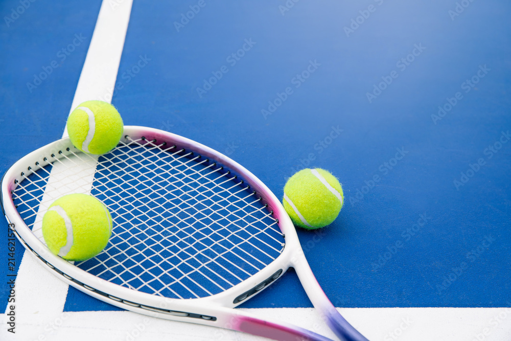 Tennis ball and tennis racket on a tennis court. Close up of tennis ball  and tennis racket on hard court. Stock Photo | Adobe Stock