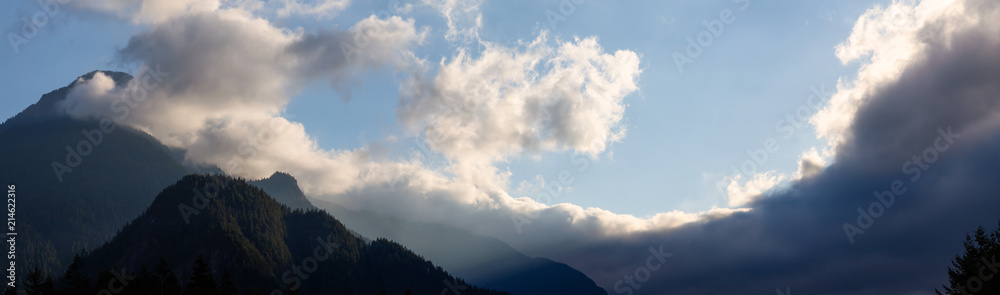 Panoramic view of the striking cloudy sky over the Canadian Mountain Landscape during a vibrant sunset. Taken in Hope, BC, Canada. Panoramic view of the striking cloudy sky over the Canadian Mountain Landscape during a vibrant sunset. Taken in Hope, BC, Canada.