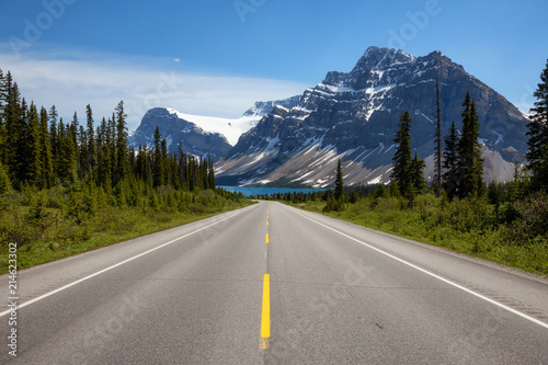 Scenic road in the Canadian Rockies during a vibrant sunny summer day. Taken in Icefields Parkway, Banff National Park, Alberta, Canada.