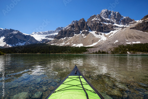 Kayaking in a glacier lake during a vibrant sunny summer day. Taken in Bow Lake, Banff National Park, Alberta, Canada.