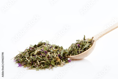 Medicinal herbal tea leafs in a wooden spoon on white background. Health and beauty concept.