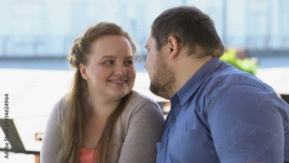 Sweet couple in love nuzzling sitting on city bench, weekend together, closeness Sweet couple in love nuzzling sitting on city bench, weekend together, closeness