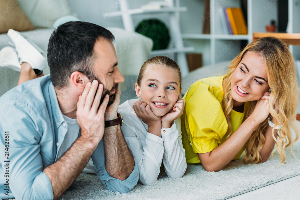 Obraz premium happy young family lying on floor at home together