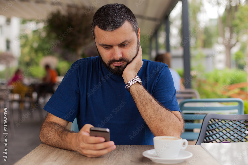 Worried man holding and using phone Worried man holding and using phone