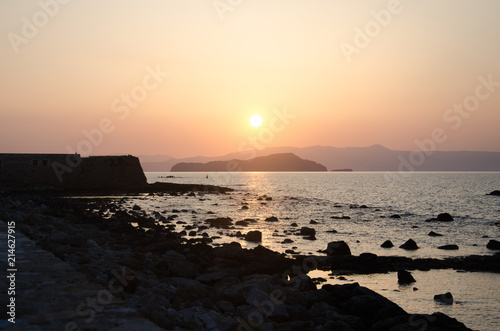 Beautiful sunset over mountains near sea. Sunset and red orange sky over mountain in Greece  Chania. Mediterranean Sea