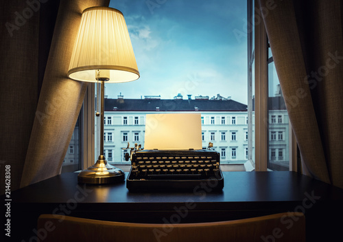 Workplace of a writer, journalist, creator. An old typewriter and a lamp on the table. Retro style. The concept on scientific, historical, literature, education and philosophical topics. photo