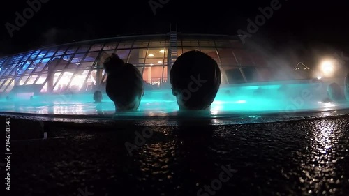 Timelapse of thermal water with water vapor and people in the foreground in Bad Gastein in Austria photo