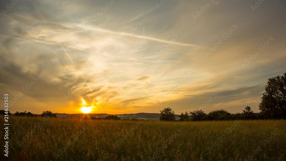 Beautiful sunset time laspe shot in a rural area with tall high grass growing in the foreground. Beautiful sunset time laspe shot in a rural area with tall high grass growing in the foreground.
