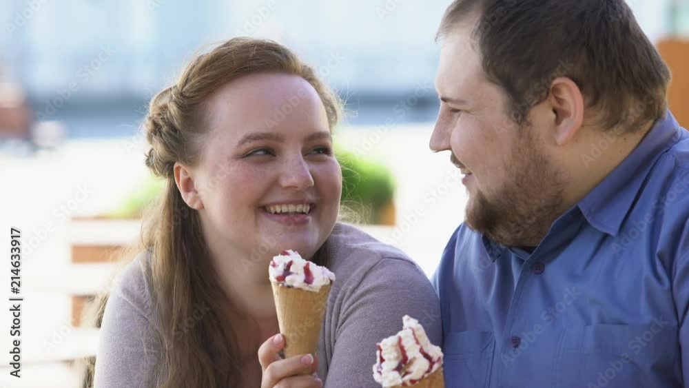 Flirting young woman touching boyfriend nose with ice-cream, playful mood Flirting young woman touching boyfriend nose with ice-cream, playful mood