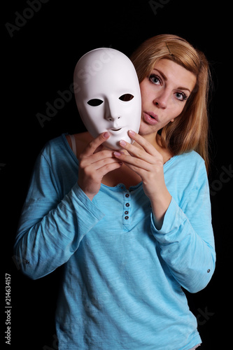 young woman removing plain white mask from her face