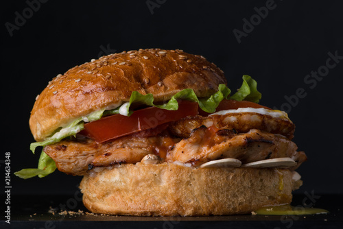 juicy cheeseburger on a black background, close-up