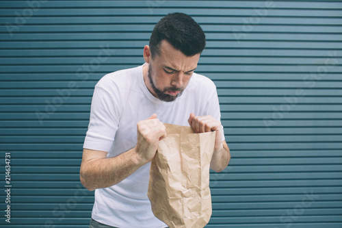 фотографія A picture of sick man trying to vomit in paper bag