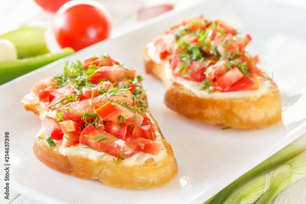 Bruschetta with fresh tomatoes and cheese on white boards next to fresh vegetables. Close-up