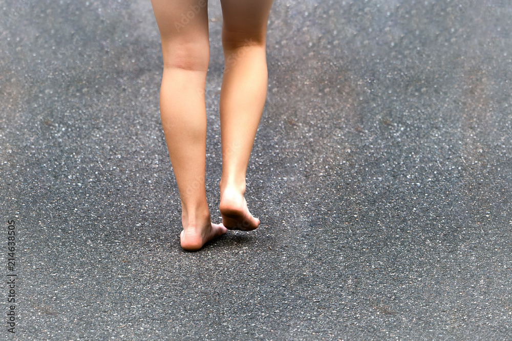 Barefoot legs of a young girl walking on a dirty road. Barefoot legs of a young girl walking on a dirty road.