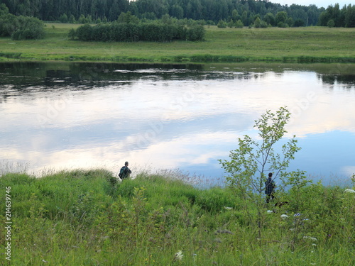 Fishing on the river bank in the summer evening