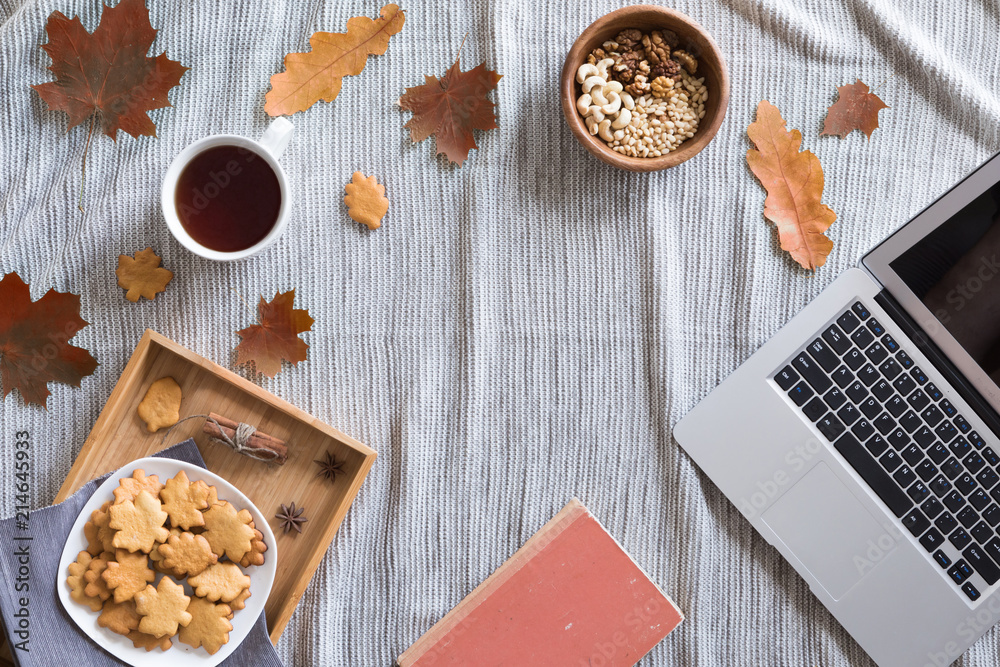 Flat lay and top view of home office desk. Workspace with woman hands, laptop, autumn leaves and flowers, cookies, coffee on cozy background Flat lay and top view of home office desk. Workspace with woman hands, laptop, autumn leaves and flowers, cookies, coffee on cozy background