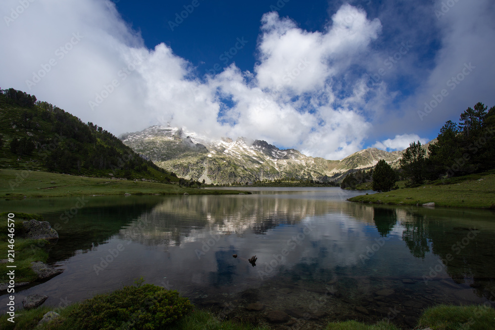 Lac d'Aumar dans la réserve naturelle de Néouvielle avec montagne enneigée en fond Lac d'Aumar dans la réserve naturelle de Néouvielle avec montagne enneigée en fond