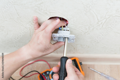 Male electrician puts on and repair an electrical outlet