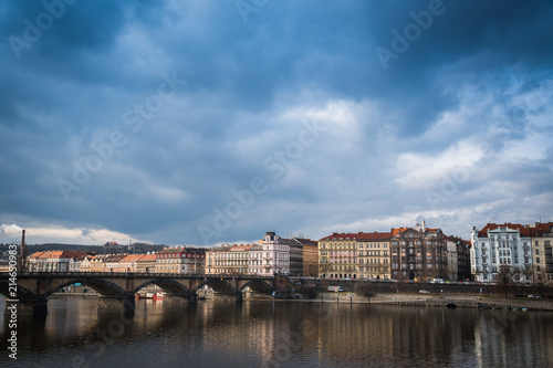 Palacky bridge over Vltava river in Prague, Czech Republic. Buildings and cloudy sky in the background. Space in the top side