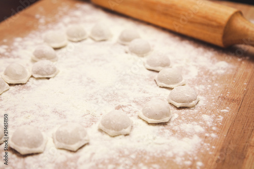 flour and dumplings on wooden board