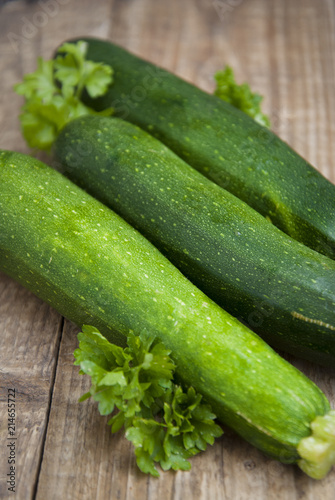 Fresh organic zucchini isolated on rustic wooden background. Summer vegetables, space for text.