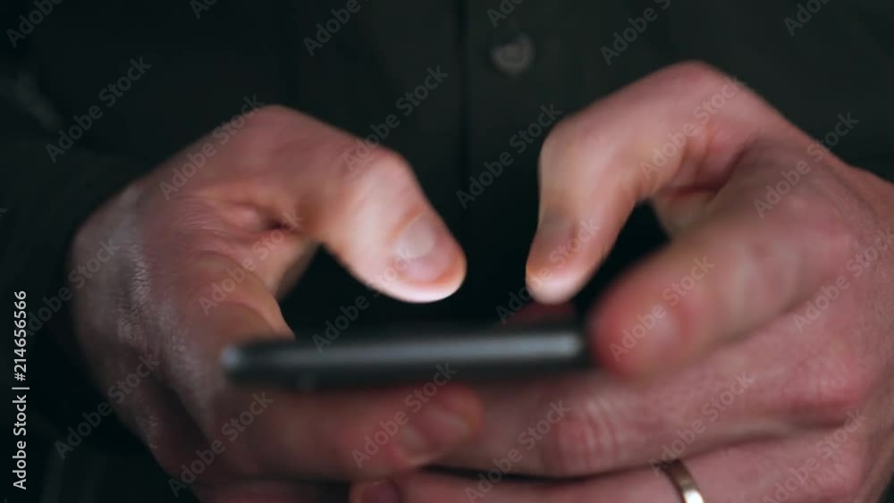 Businessman scrolling through messages on his cellphone Businessman scrolling through messages on his cellphone
