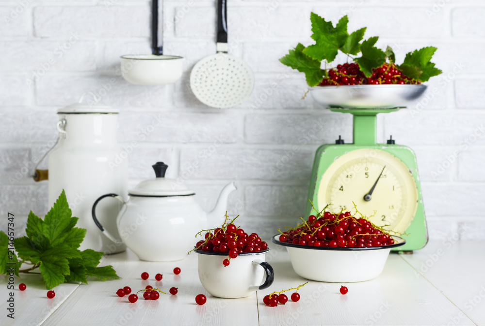 Red currant berries in a cup and bowl on the kitchen table Red currant berries in a cup and bowl on the kitchen table