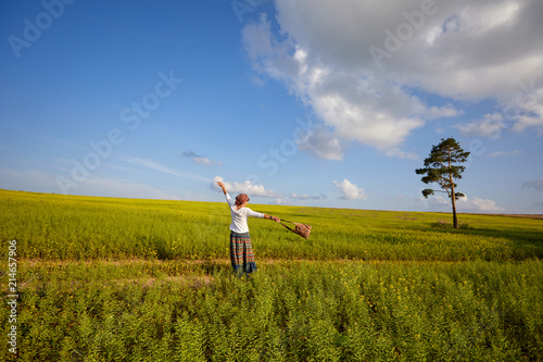 A young woman is playing on a flowering meadow. Enjoy life