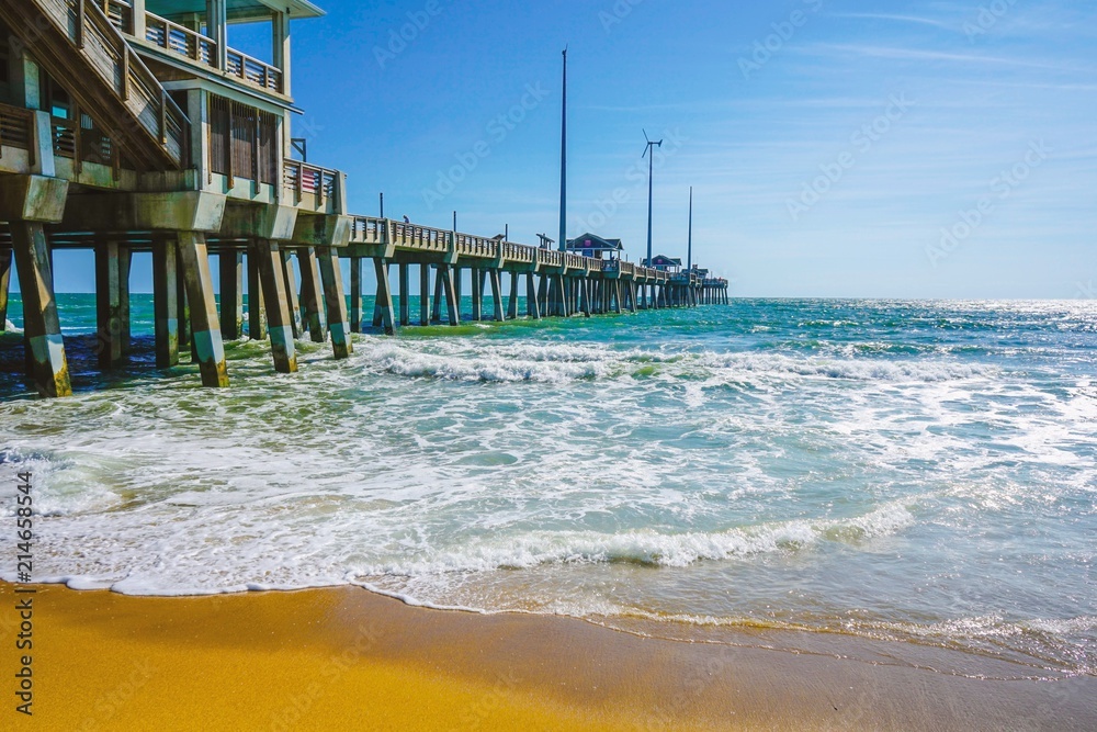 An ocean landscape with bubbly waves at Jennette's Pier in North Carolina in Summer. Copy space.