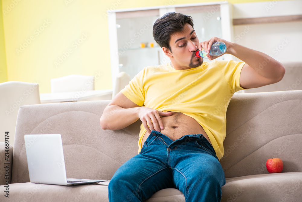 Man suffering from extra kilos in dieting concept Man suffering from extra kilos in dieting concept