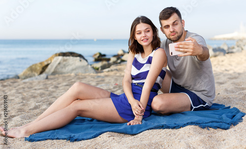 Young loving couple resting and taking selfie