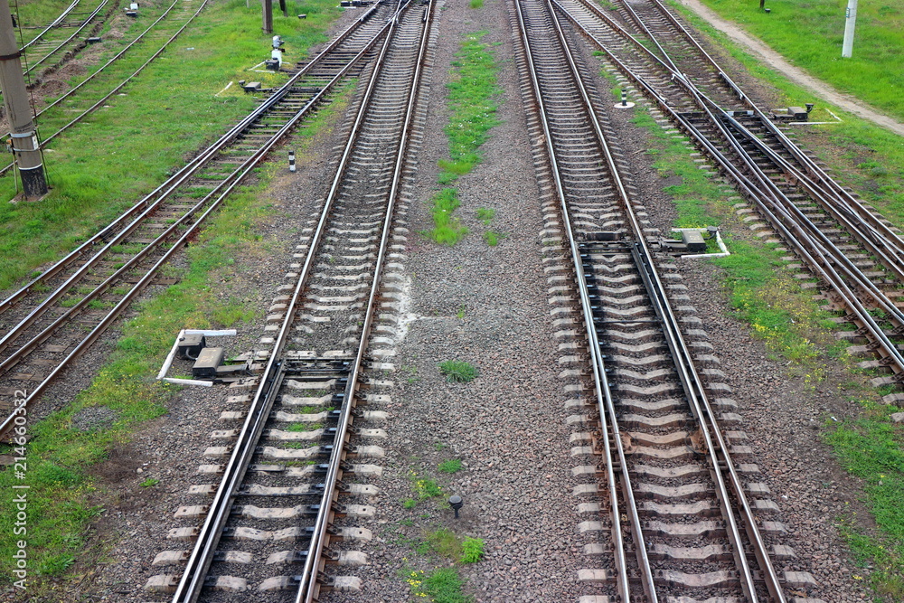 Railway, the top view on rails. Leading parallel steel rails with regular crossbars. Abstract geometric view.