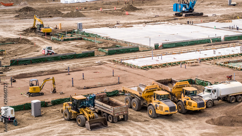 фотографія Aerial View Dump Trucks, Pailloader, Mini Excavator, High Hoe on busy job site,