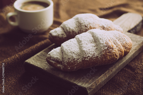 Freshly baked croissants with a cup of hot coffee. 