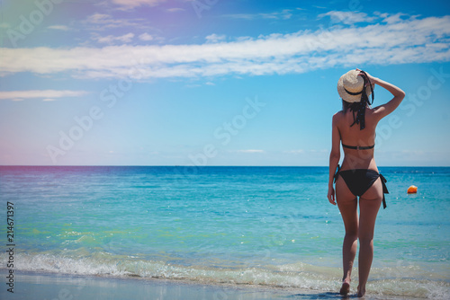 Young caucasian girl in black bikini on a beach in summertime. Odessa, Ukraine © Masson