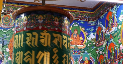 Buddhist art and decoration in ancient temple of Ladakh. Spinning prayer wheel in monastery photo