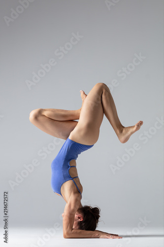 Young beautiful yoga woman is posing in studio