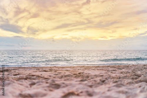 Colourful beach sunset with orange sky  Low angle with blurry sand in foreground