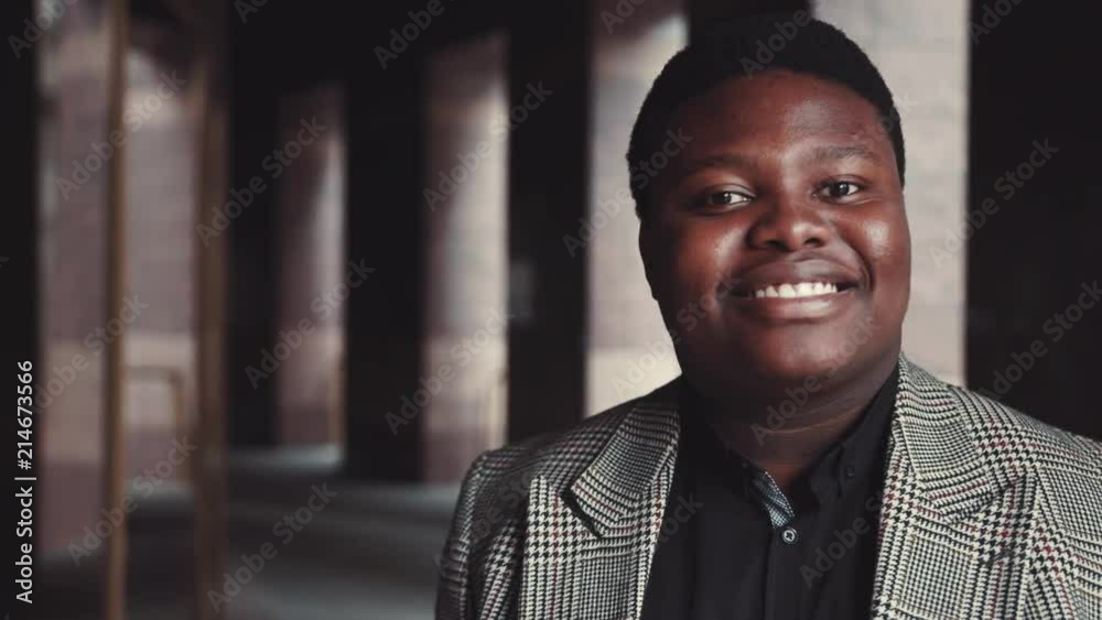 Dreamy joyful Afro-American man in trendy outfit looks straight to camera smiling happily. Positive mood, being happy, joy of life. Positive atmosphere. Male portrait, close up view Dreamy joyful Afro-American man in trendy outfit looks straight to camera smiling happily. Positive mood, being happy, joy of life. Positive atmosphere. Male portrait, close up view