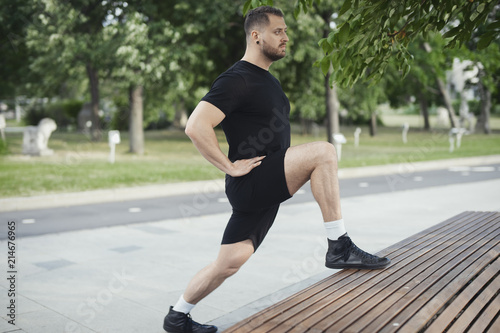 Fitness man doing lunges leg exercise outdoors.