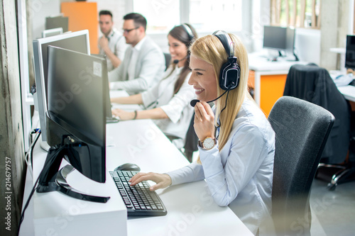 Attractive young woman working in a call center with her colleagues photo
