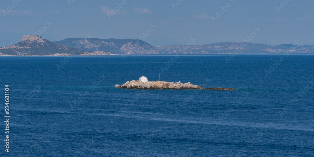 Whitewashed temple on rocky island in Mediterranean
