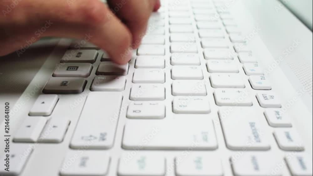 Young man typing on a notebook keyboard Young man typing on a notebook keyboard