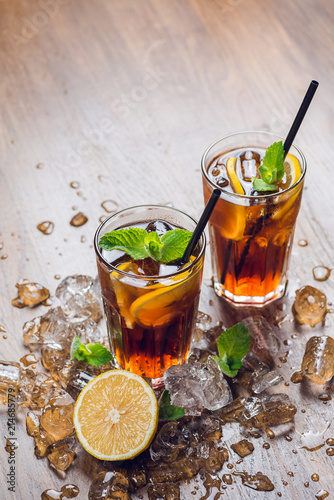 Traditional ice tea, chilled, with lemon, mint and ice on rustic table