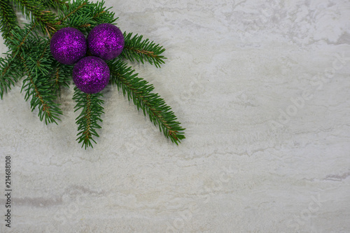 three purple ornaments on a spruce bough