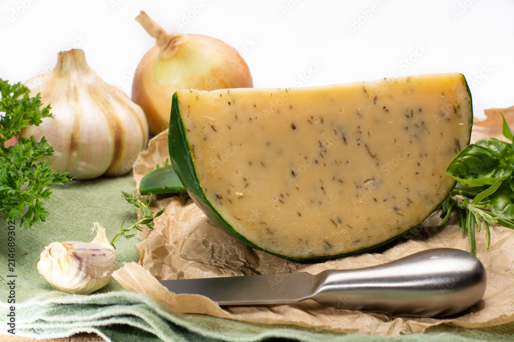 Dutch specialty hard cheese made from cows milk with different spices and fresh green herbs Dutch specialty hard cheese made from cows milk with different spices and fresh green herbs
