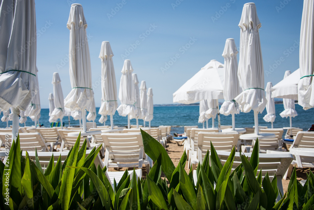 Obraz premium Rest by the sea. Beach with sun loungers. warm countries. Chaise lounge. Place for sunburn. Solar procedures. Side, Turkey